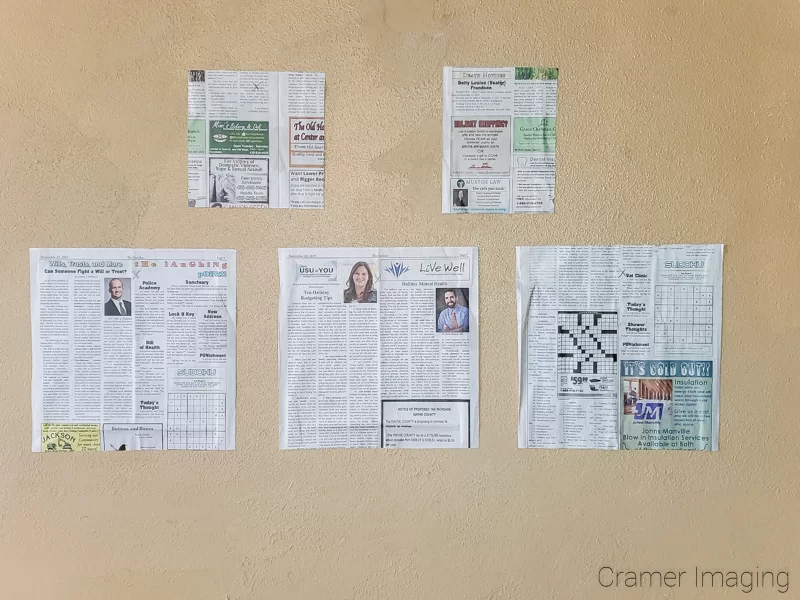 Audrey Cramer Photography's photograph of newspaper templates on the wall arranged to hang a gallery wall presentation