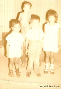 Old and acid-damaged faded photo of siblings