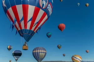 Cramer Imaging's fine art photograph of several hot air balloons taking flight in Panguitch Utah with a blue morning sky