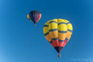 Cramer Imaging's fine art photograph of three hot air balloons taking flight in Panguitch Utah with a blue morning sky