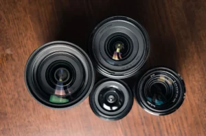 Photograph of a cluster of 4 lenses sitting on a wooden surface