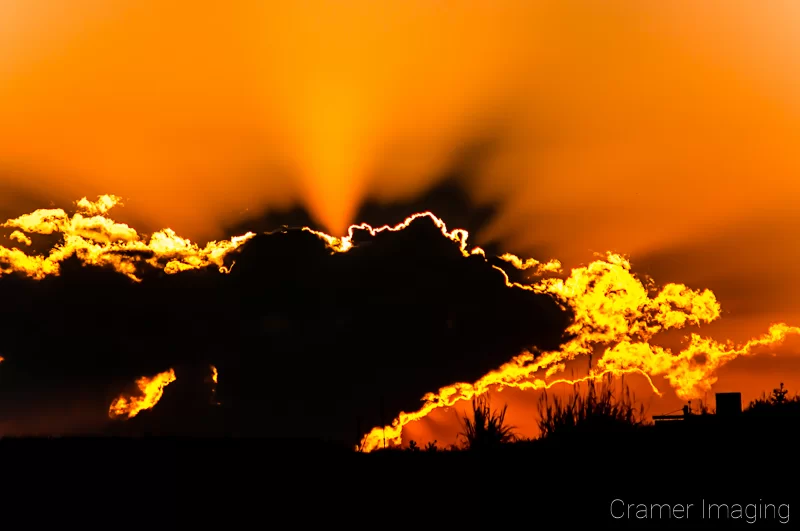 Audrey Cramer Photography's professional landscape photograph of a dramatic orange sunset with clouds in silhouette