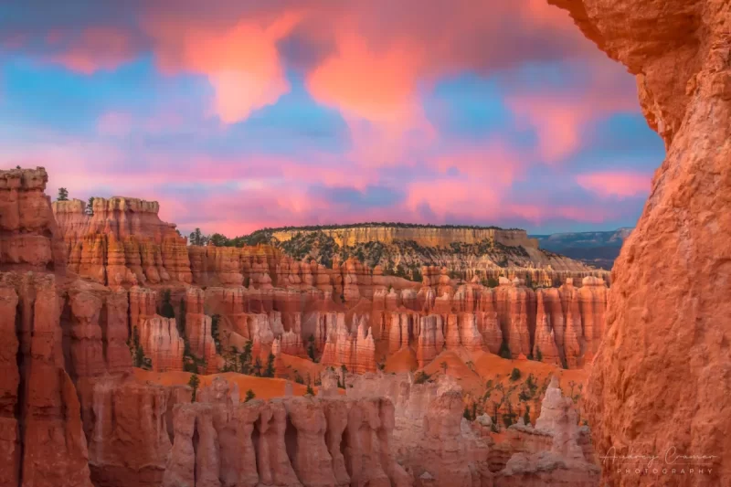 Audrey Cramer Photography's fine art landscape photograph of fiery orange clouds lighting up over the Boat Mesa in Bryce Canyon National Park Utah