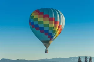 Cramer Imaging's fine art photograph of a rainbow hot air balloon drifting over the landscape in Panguitch Utah