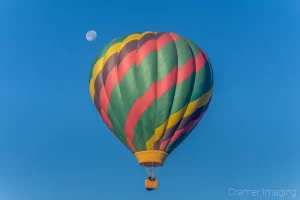 Cramer Imaging's fine art photograph of a colorful hot air balloon drifing by the moon