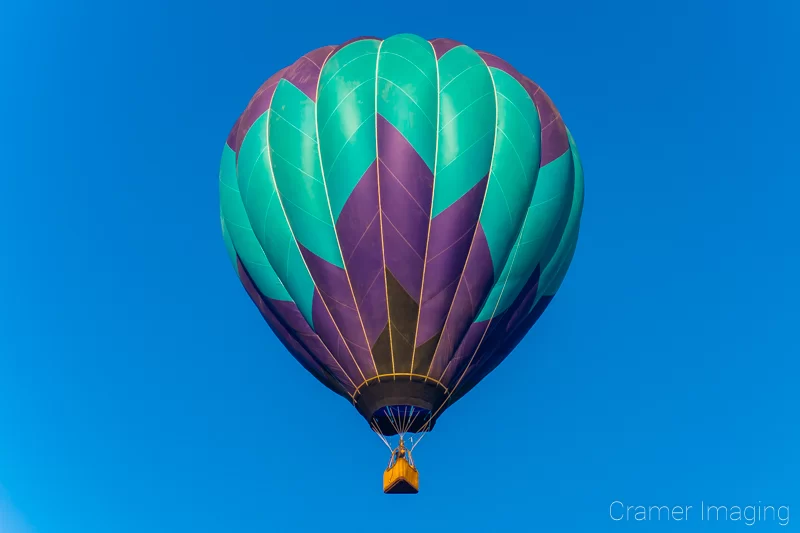 Audrey Cramer Photography's fine art photograph of a purple and teal hot air balloon drifting in the sky