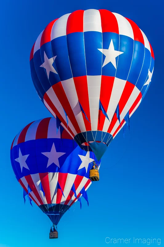 Cramer Imaging's fine art photograph of two patriotic hot air balloons flying close together in the sky