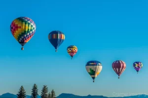 Cramer Imaging's fine art photograph of six hot air balloons in a reverse s shape drifting over the Panguitch Utah landscape