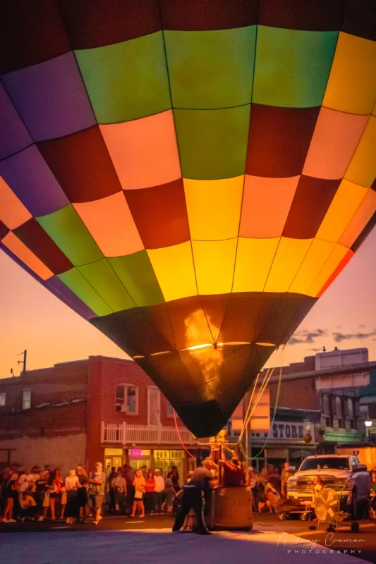 Audrey Cramer Photography's fine art photograph of the Panguitch Utah hot air balloon glow on main street with a jet of fire showing