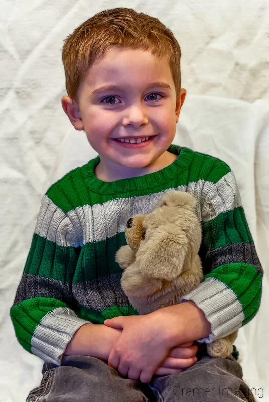 Portrait of a young boy holding a stuffed dog