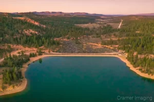 Aerial landscape photograph of the Tropic Reservoir, dam, and surrounding landscape in Garfield Utah