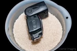 Cramer Imaging's professional quality photograph of a removable camera flash in a bowl of white rice