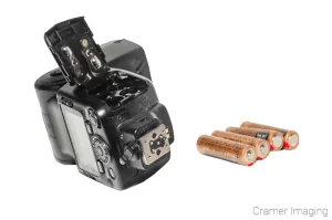 Cramer Imaging's professional quality product photograph of a removable camera flash and AA batteries