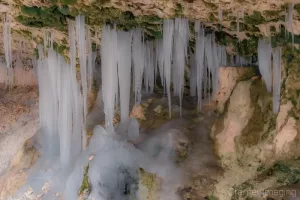 Cramer Imaging's fine art nature photograph of moss and icicles hanging down as stalagmites in a cave