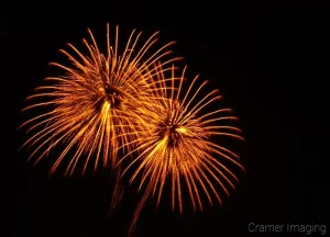 Two orange fireworks professionally photographed by Cramer Imaging