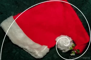 Cramer Imaging's professional quality fine art photograph of a red and white Santa hat on a green background