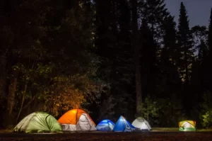 Photo of a group of tents lit up at night at a campground