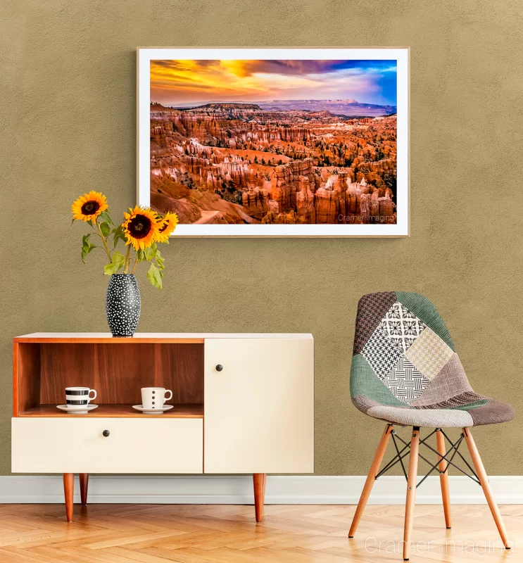 Photo of Audrey Cramer Photography's "Sunset at Bryce" on the wall of a warm-toned room with a chair and desk