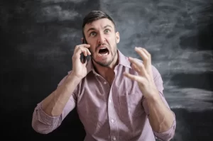 Photograph of an angry man talking on a cell phone