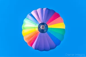 Fine art photograph of a soaring hot air balloon against the blue sky in Panguitch, Utah by Cramer Imaging