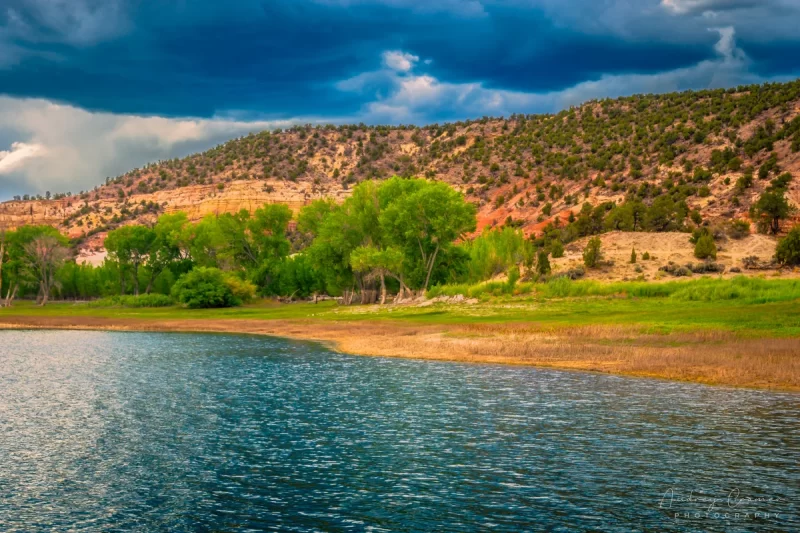 Fine art landscape photograph of moody monsoon skies and troubled waters at Wide Hollow Reservoir in Escalante, Utah by Audrey Cramer Photography