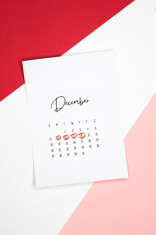 Calendar of the month of December with 4 dates circled on a colored background