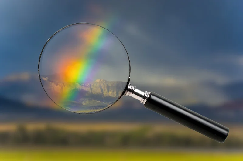 Image of a magnifying glass magnifying a section of a Audrey Cramer Photography landscape photo titled "Broken Rainbow"