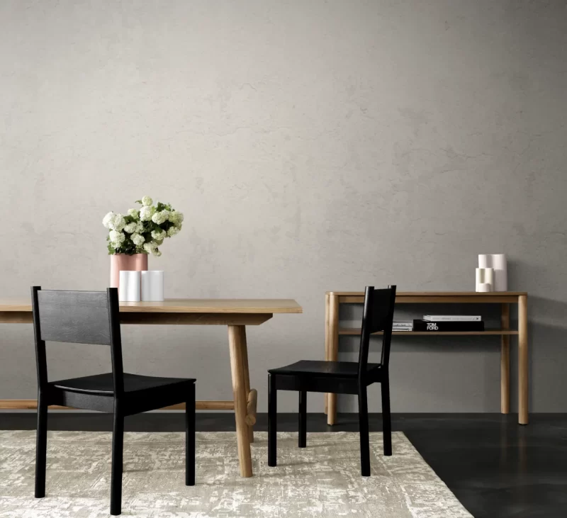 Photograph of a neutral dining area with a blank wall and white flowers