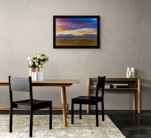 Photograph of a neutral dining area with a Audrey Cramer Photography's "Open Range" on the wall and white flowers