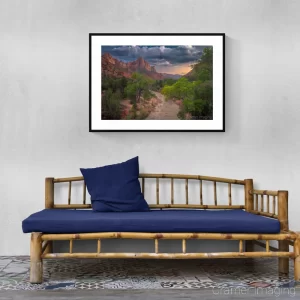 Photograph of Cramer Imaging's landscape photo "Pa'rus" on a gray wall with a rustic-style bench with blue cushion and pillow