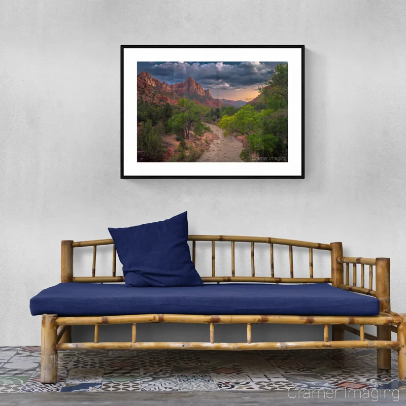 Photograph of Audrey Cramer Photography's landscape photo "Pa'rus" on a gray wall with a rustic-style bench with blue cushion and pillow