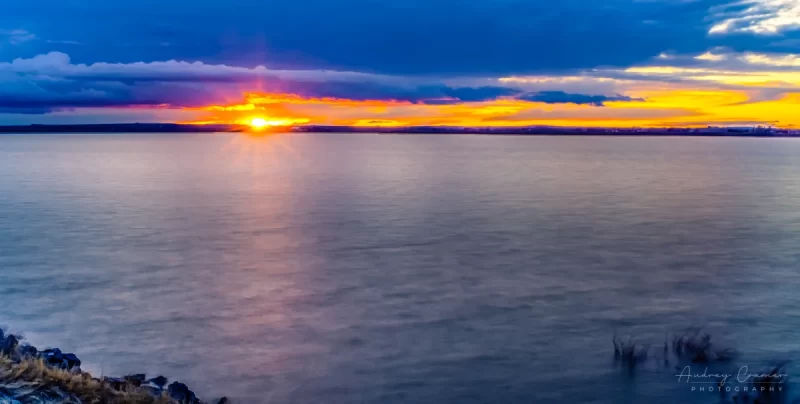 Audrey Cramer Photography's fine art landscape photograph of American Falls reservoir at sunset with a sunburst in Idaho