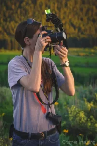 Landscape photographer Audrey holding up a camera and taking a picture by Audrey Cramer Photography