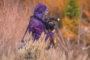 Professional landscape photographer Audrey Cramer out in sagebrush taking a winter photo