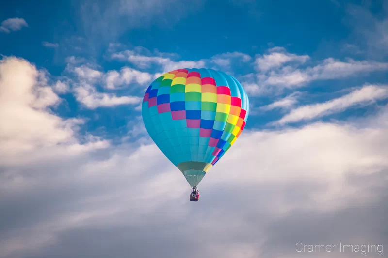 Audrey Cramer Photography's fine art photograph of one colorful hot air balloon taking flight in Panguitch Utah with a blue morning sky