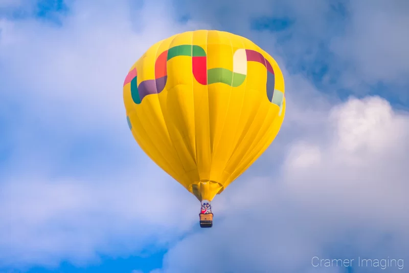 Audrey Cramer Photography's fine art photograph of one yellow hot air balloon taking flight in Panguitch Utah with a cloudy morning sky