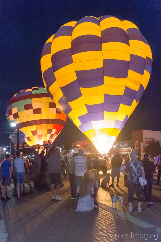 Audrey Cramer Photography's fine art photograph of a hot air balloon glow featuring 2 balloons at night in the streets of Panguitch Utah