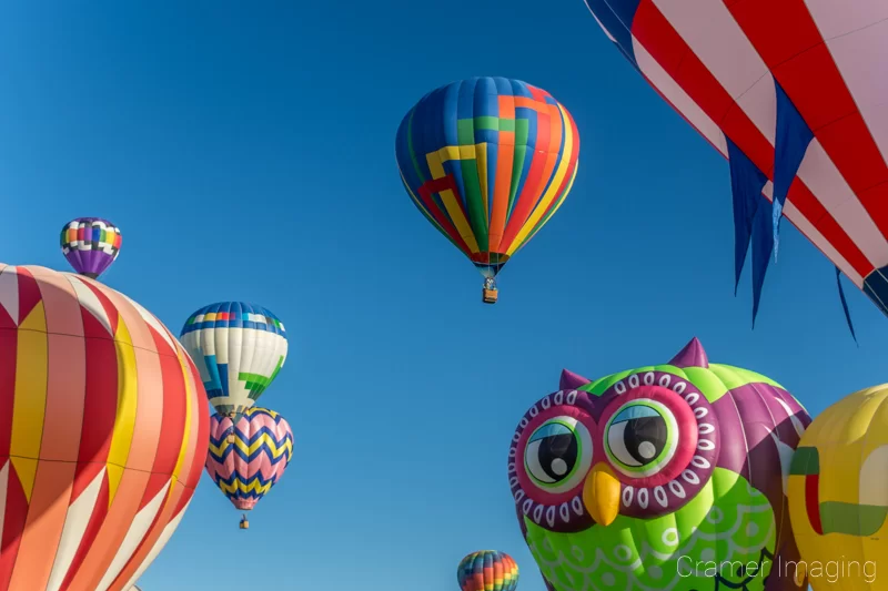 Audrey Cramer Photography's fine art photograph of many hot air balloons taking flight in Panguitch Utah with a blue morning sky