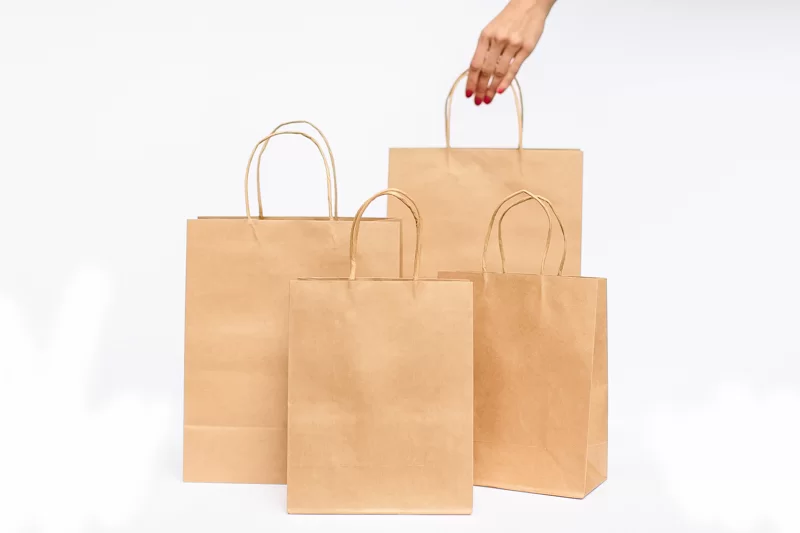 Photograph of four brown paper shopping bags standing in a group