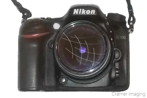 Cramer Imaging's photograph of a DSLR camera with a scratched lens