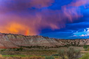 Cramer Imaging's fine art landscape photograph of dramatic clouds and a rainbow above the Cannonville Utah landscape