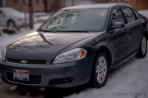 Photograph of a sedan style grey car parked on snow by Audrey Cramer Photography