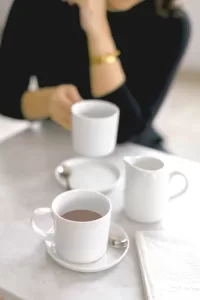 Picture of a female client sitting at a table with a cup of hot chocolate