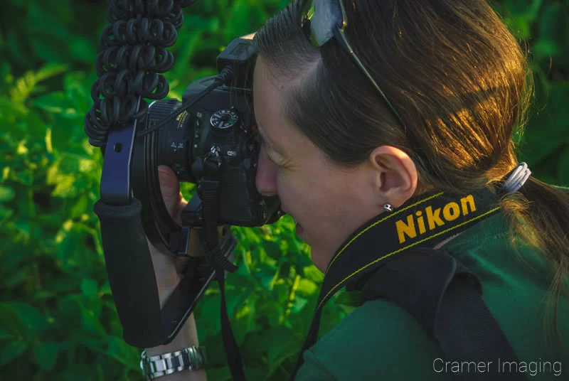 Photo of professional landscape photographer Audrey with camera in hand taking a picture by Cramer Imaging