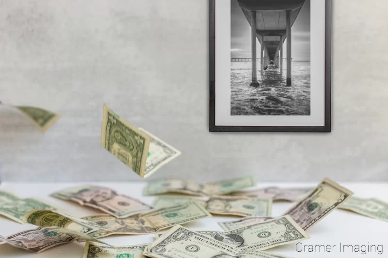 Photograph of falling money on a table and Cramer Imaging's fine art landscape photo titled "San Diego Pier"