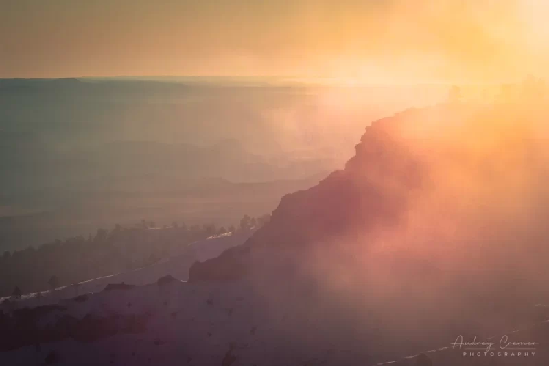 Audrey Cramer Photography's fine art landscape photograph of the sun shining into a foggy snow-covered landscape at Bryce Canyon National Park, Utah