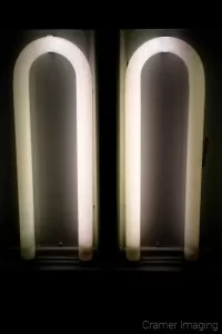 Cramer Imaging's photograph of two flourescent lights without covers on the ceiling