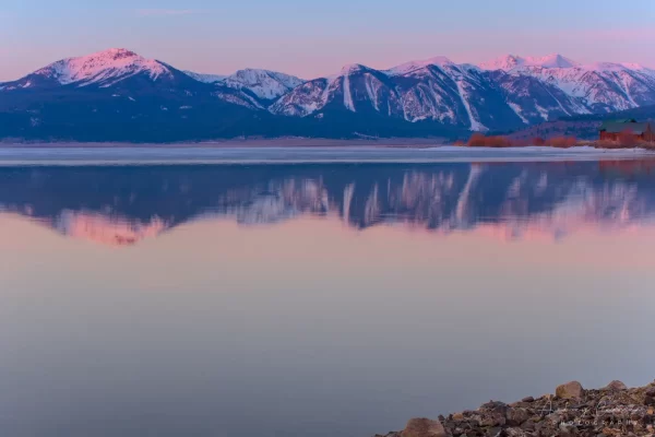 Cramer Imaging's professional quality landscape photograph of mountains and a cabin reflecting in Henry's Lake at dawn