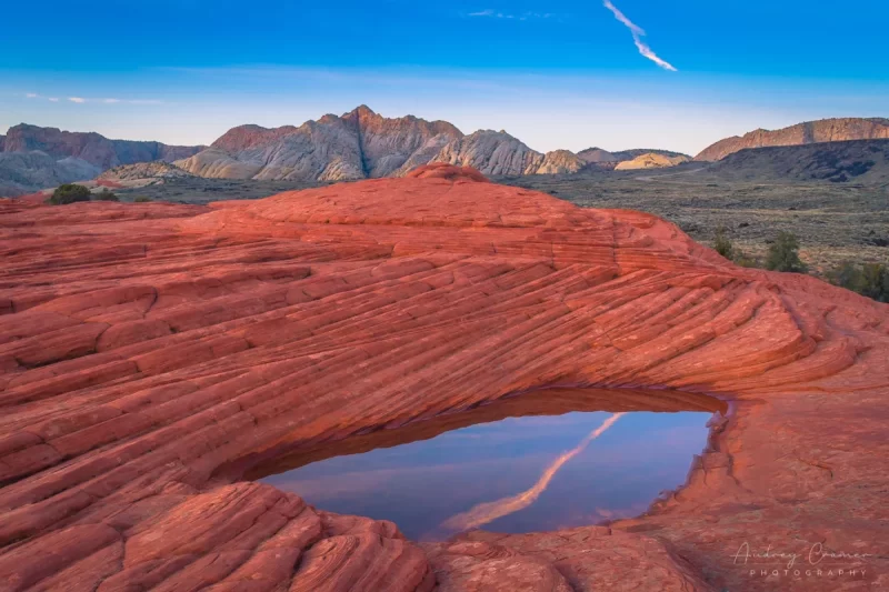 Audrey Cramer Photography's fine art landscape photograph of a hidden pool atop layered red rocks reflecting the sky in Snow Canyon State Park, Utah