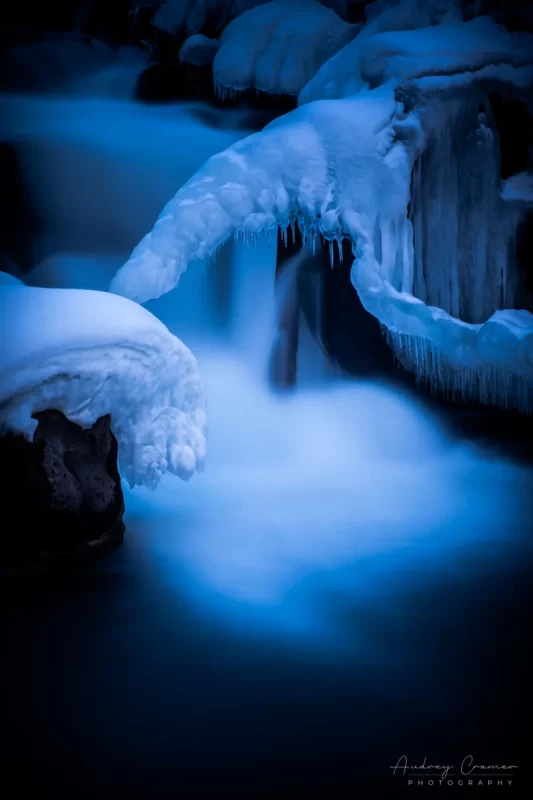 Audrey Cramer Photography's nature photograph of a silky waterfall in the snow during winter in Idaho Falls, Idaho